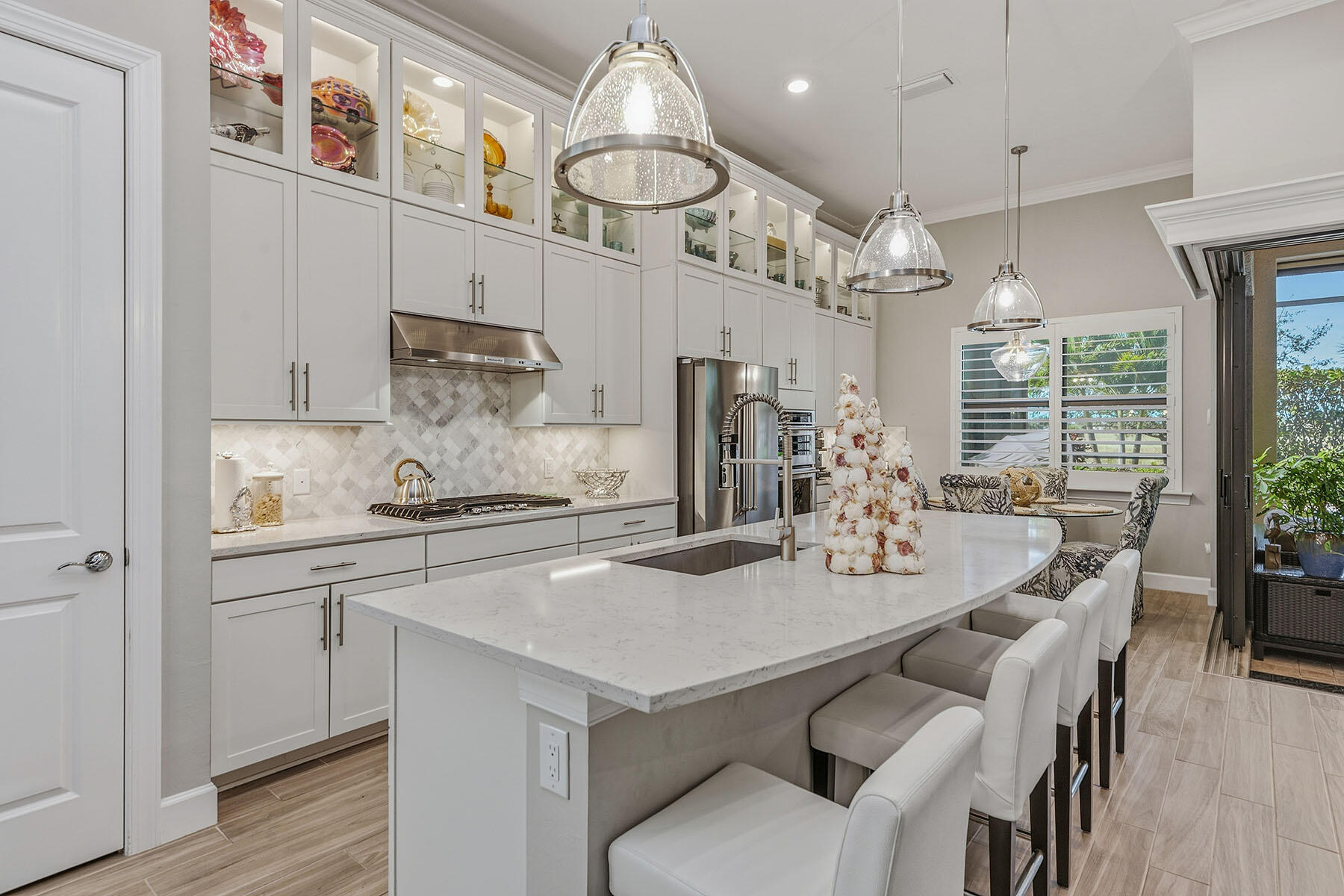 2797 Amaranda Court Naples, FL 34114 - Photo 4 of 50 a kitchen with stainless steel appliances a table chairs and a chandelier