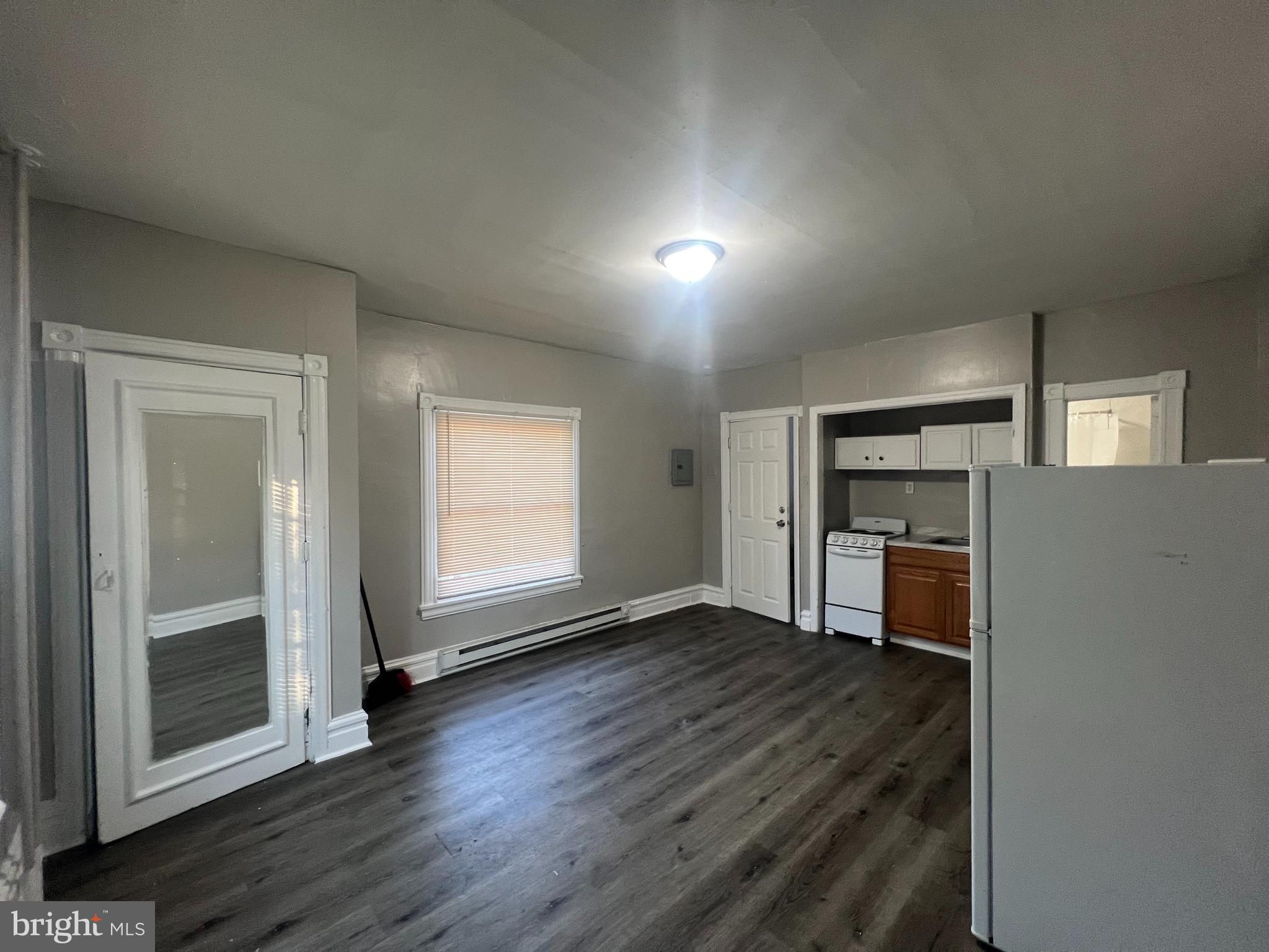 4637 Leiper Street, Unit 4 Philadelphia, PA 19124 - Photo 3 of 4 an empty room with wooden floor fireplace and windows