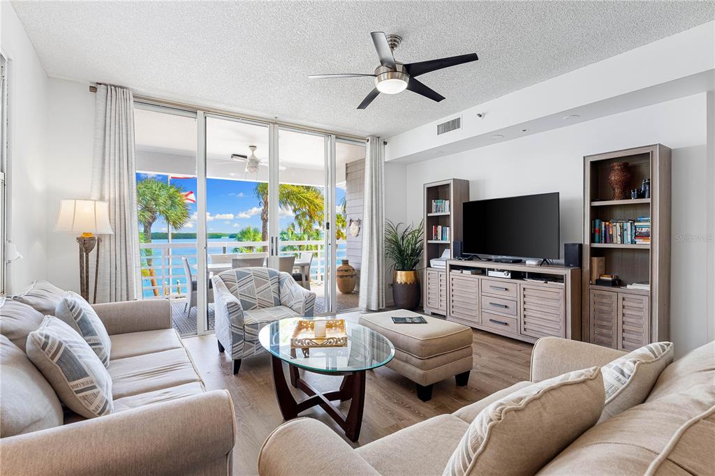 615 Dream Island Road, Unit 202 Longboat Key, FL 34228 - Photo 11 of 66 a living room with furniture and a flat screen tv