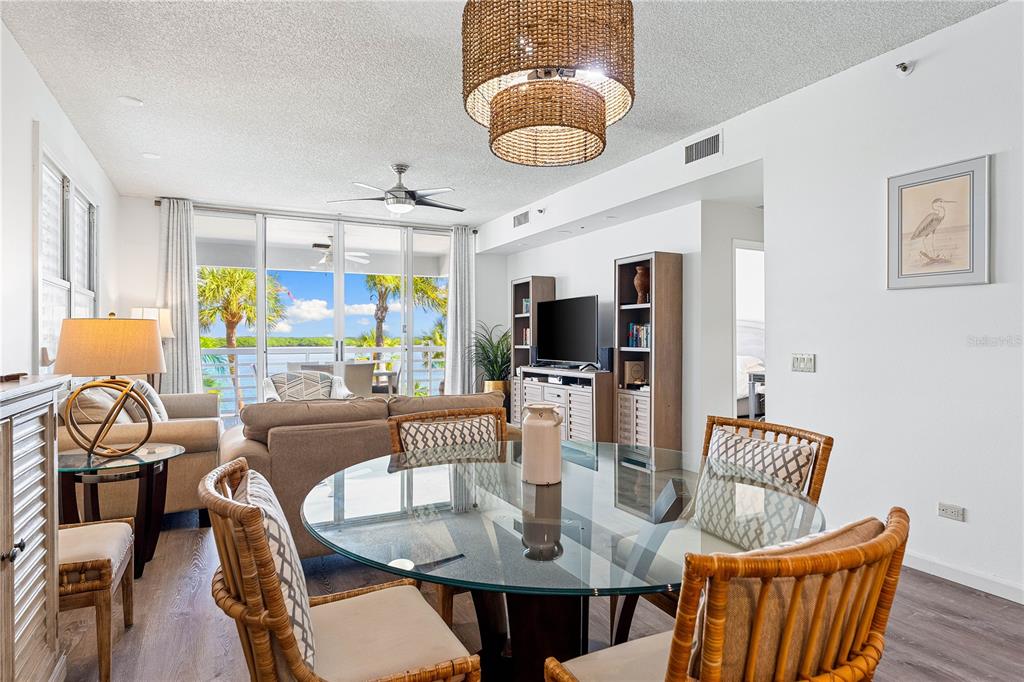 615 Dream Island Road, Unit 202 Longboat Key, FL 34228 - Photo 12 of 66 a dining room with furniture a flat screen tv and a large window