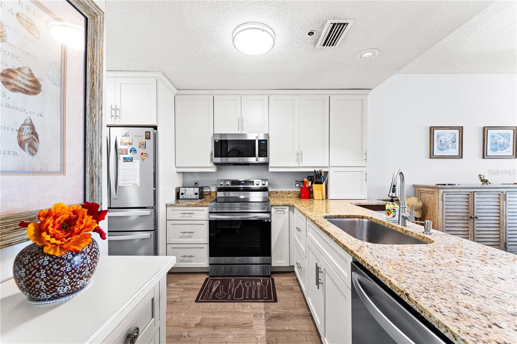 615 Dream Island Road, Unit 202 Longboat Key, FL 34228 - Photo 17 of 66 a kitchen with stainless steel appliances granite countertop a sink stove and refrigerator