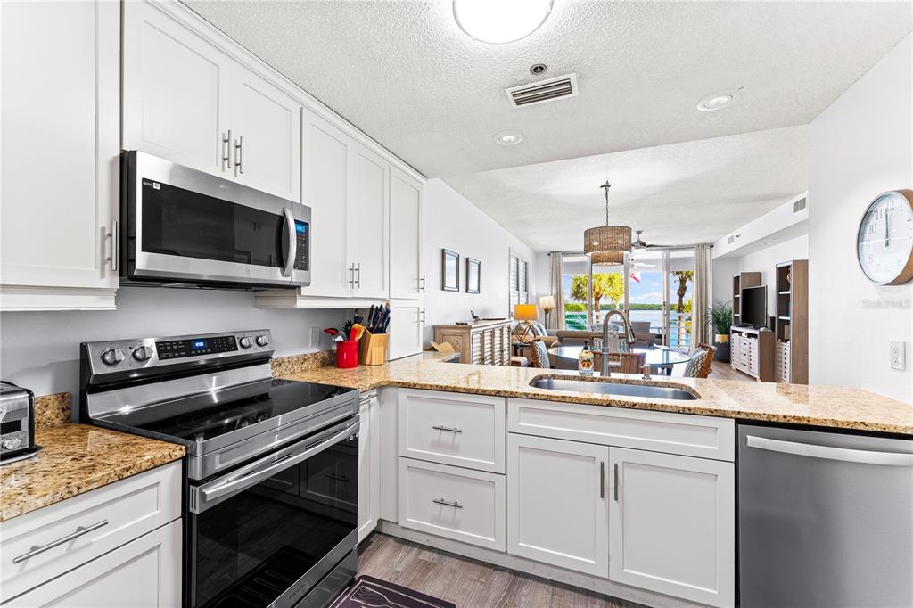 615 Dream Island Road, Unit 202 Longboat Key, FL 34228 - Photo 18 of 66 a kitchen with white cabinets stainless steel appliances and sink