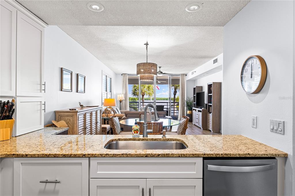 615 Dream Island Road, Unit 202 Longboat Key, FL 34228 - Photo 19 of 66 a kitchen with a granite countertop sink and a white cabinets