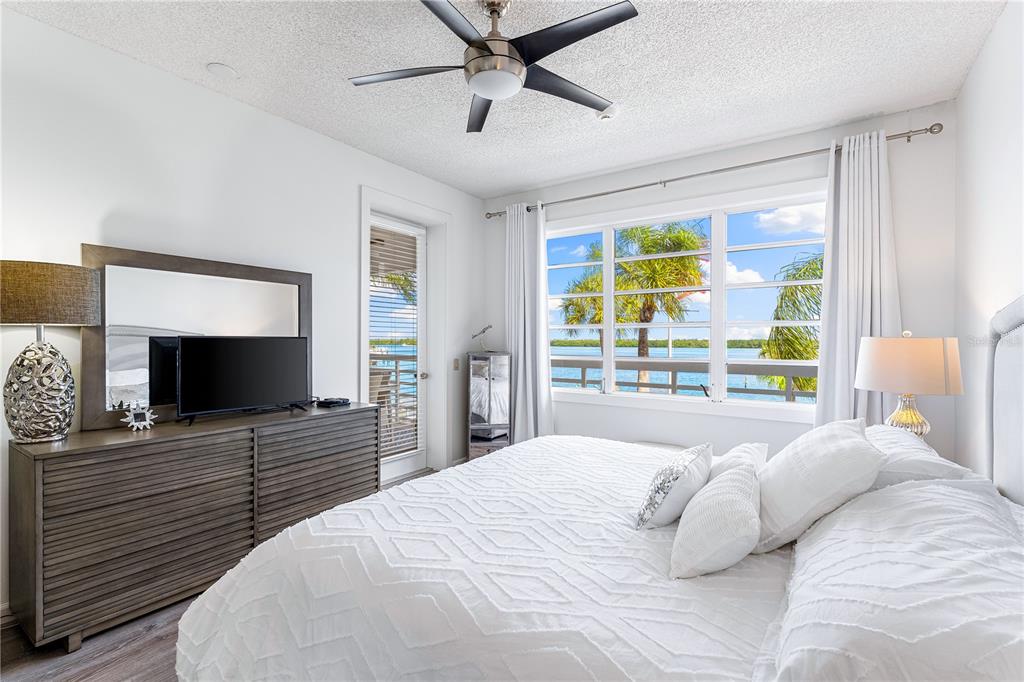 615 Dream Island Road, Unit 202 Longboat Key, FL 34228 - Photo 22 of 66 a bedroom with a large bed and a flat screen tv