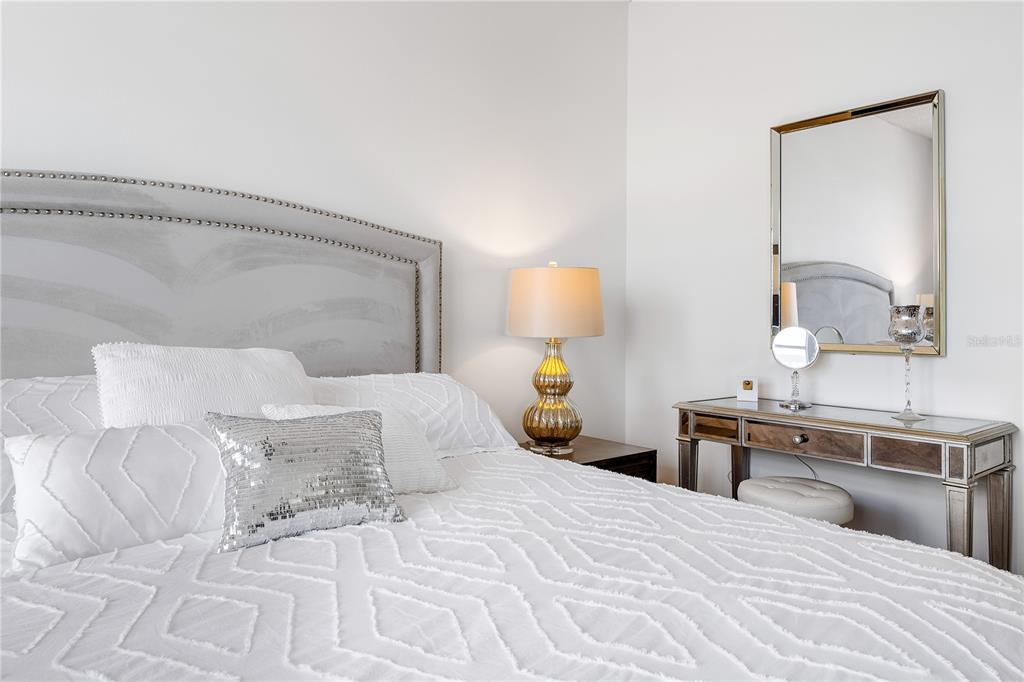 615 Dream Island Road, Unit 202 Longboat Key, FL 34228 - Photo 23 of 66 a bedroom with a bed and a lamp