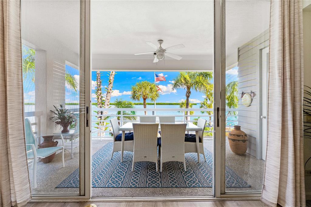 615 Dream Island Road, Unit 202 Longboat Key, FL 34228 - Photo 3 of 66 a dining room with glass top table and chairs