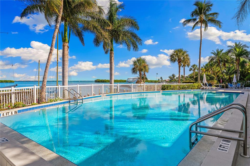 615 Dream Island Road, Unit 202 Longboat Key, FL 34228 - Photo 37 of 66 a view of swimming pool with a table and chairs