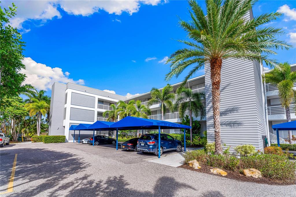 615 Dream Island Road, Unit 202 Longboat Key, FL 34228 - Photo 47 of 66 a view of a patio with a table and chairs under an umbrella