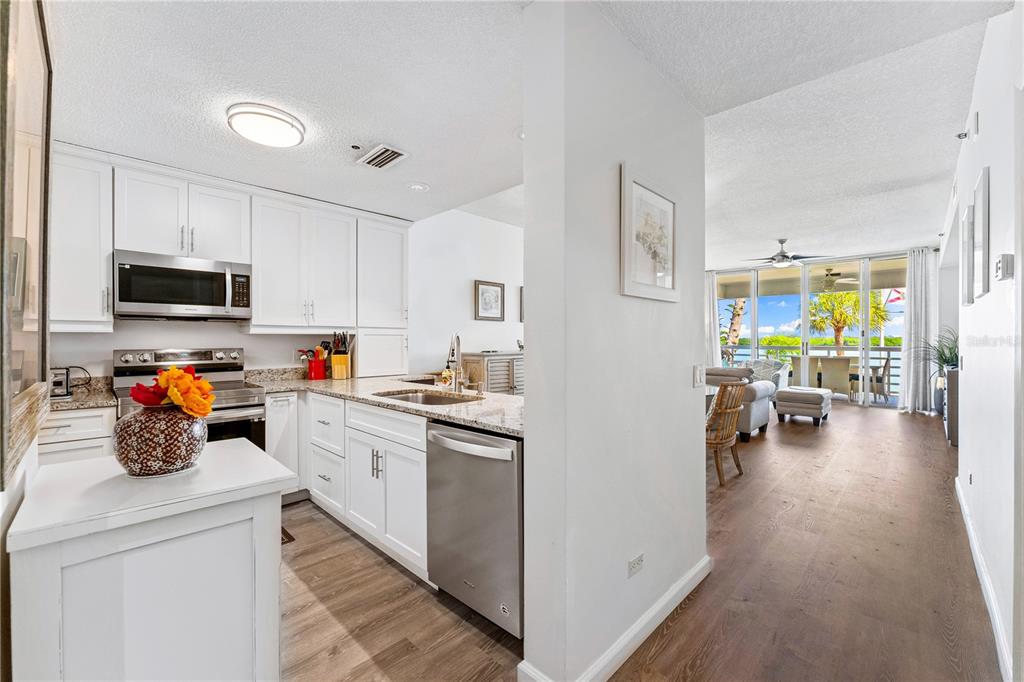 615 Dream Island Road, Unit 202 Longboat Key, FL 34228 - Photo 7 of 66 a kitchen with appliances a cabinets and wooden floor