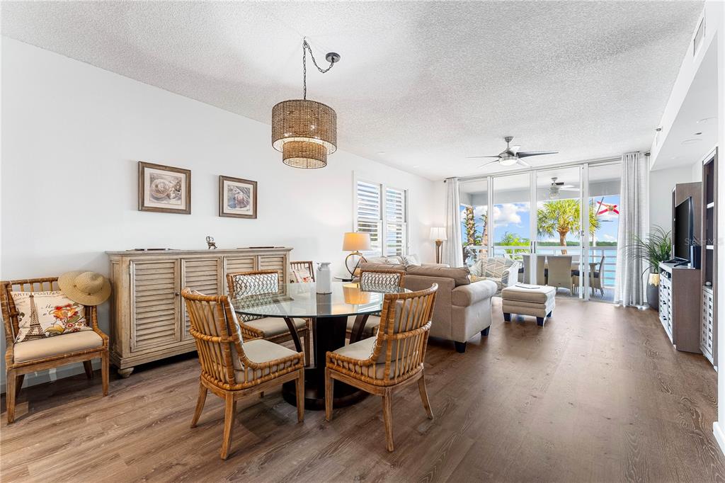 615 Dream Island Road, Unit 202 Longboat Key, FL 34228 - Photo 8 of 66 a view of a dining room with furniture wooden floor and chandelier