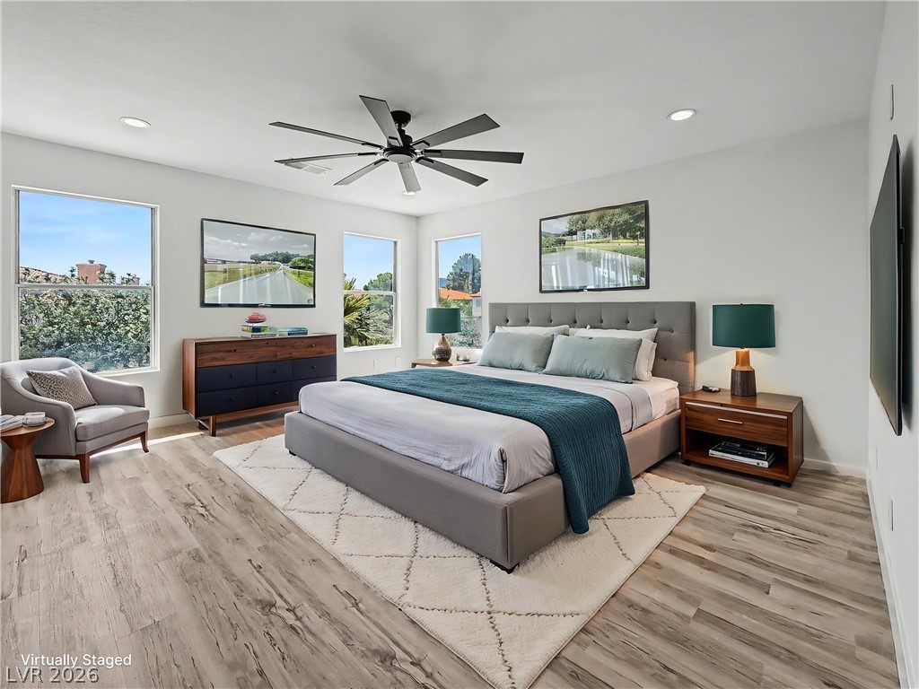 8977 Paige Rene Court Las Vegas, NV 89117 - Photo 1 of 31 Recessed lighting illuminates this bright primary bedroom featuring a ceiling fan and elegant flooring.