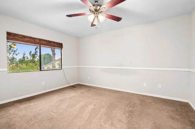 an empty room with closet and a chandelier fan