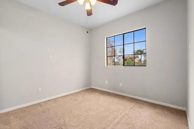 an empty room with closet and chandelier fan