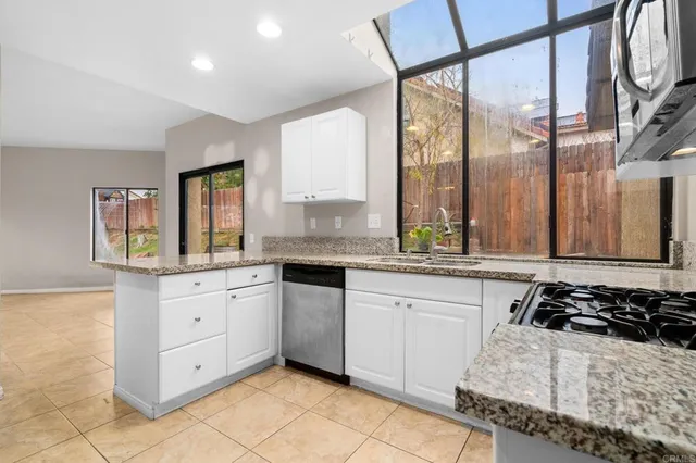a kitchen with stainless steel appliances granite countertop a stove sink and cabinets