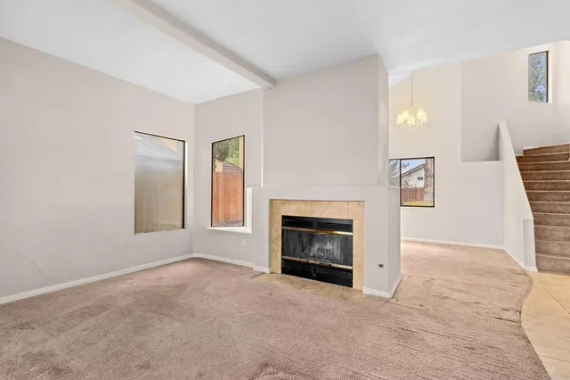an empty room with windows and fireplace