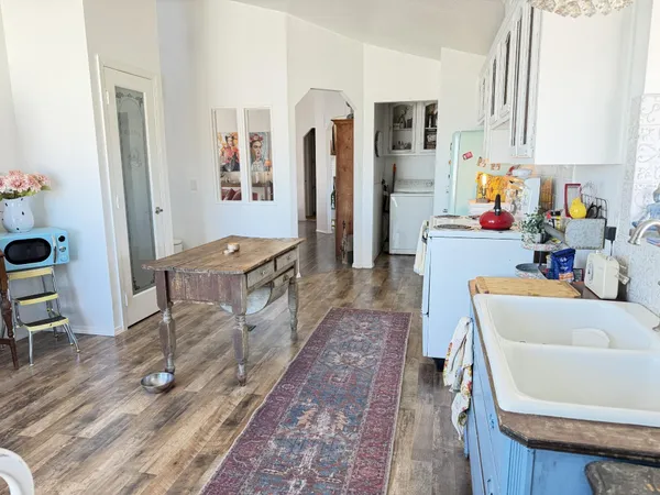 a living room with furniture and a dining table with wooden floor