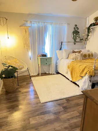 a bed sitting in a spacious bedroom next to a window
