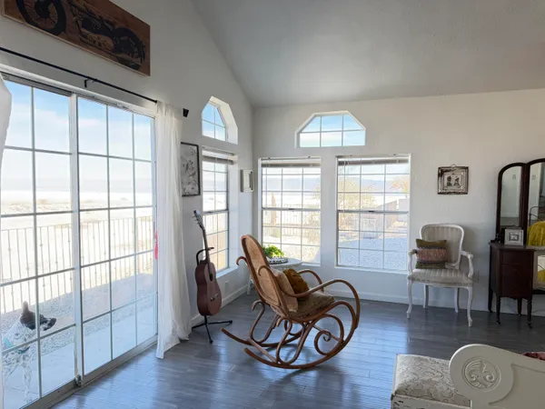 a living room with furniture floor to ceiling window and wooden floor