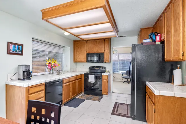a kitchen with stainless steel appliances granite countertop a refrigerator sink stove microwave and cabinets