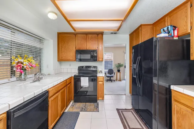 a kitchen with stainless steel appliances granite countertop a refrigerator a stove top oven a sink and dishwasher