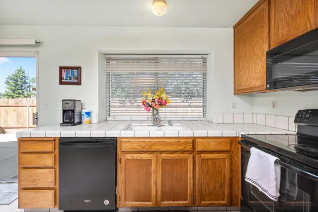 a kitchen with stainless steel appliances granite countertop a sink and a stove