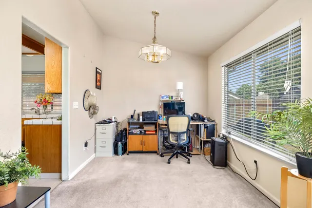 a view of a workspace with furniture and a window