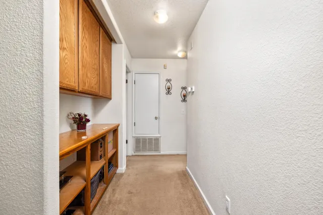 a view of a hallway to rooms and stairs