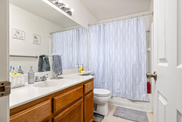 a bathroom with a sink a toilet and shower curtain
