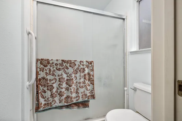 a bathroom with a toilet and a shower curtain