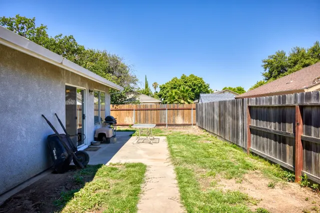 a view of backyard with tub and wooden fence