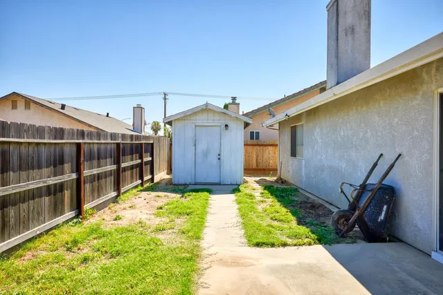a view of small yard in front of a house with wooden fence