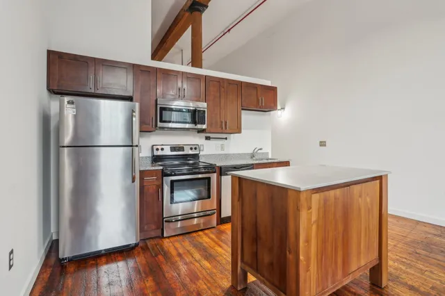 a kitchen with stainless steel appliances granite countertop a refrigerator microwave and sink