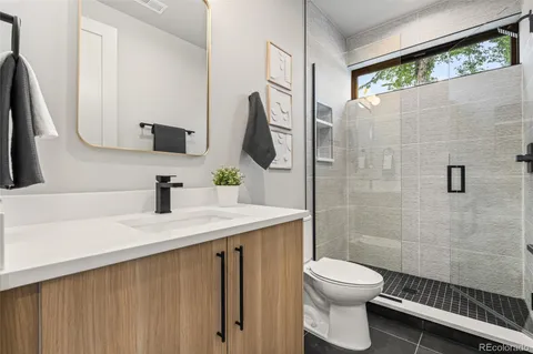a bathroom with a sink a toilet and a mirror