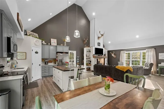 a view of a dining room with furniture a kitchen and chandelier