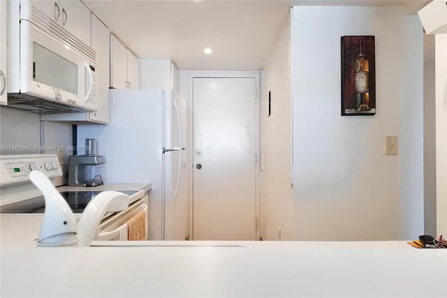 a view of kitchen with stainless steel appliances granite countertop refrigerator and cabinets