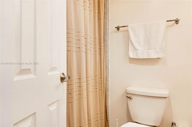 a bathroom with a shower curtain and a toilet