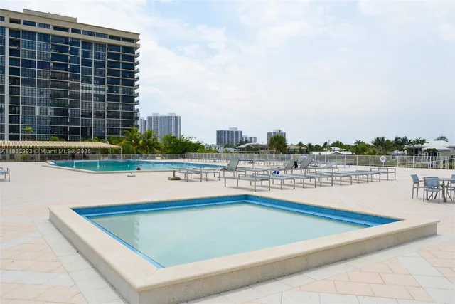 a view of swimming pool with outdoor seating and city view