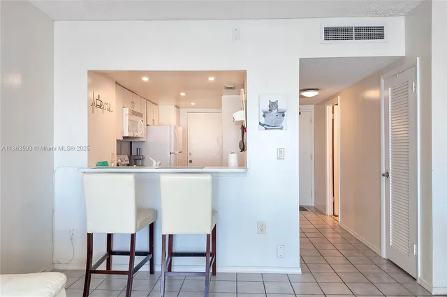 a kitchen with stainless steel appliances kitchen island granite countertop a refrigerator and a sink