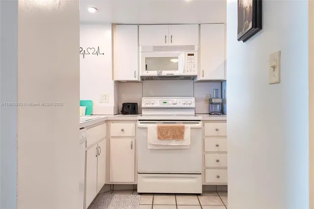 a kitchen with white cabinets and white appliances