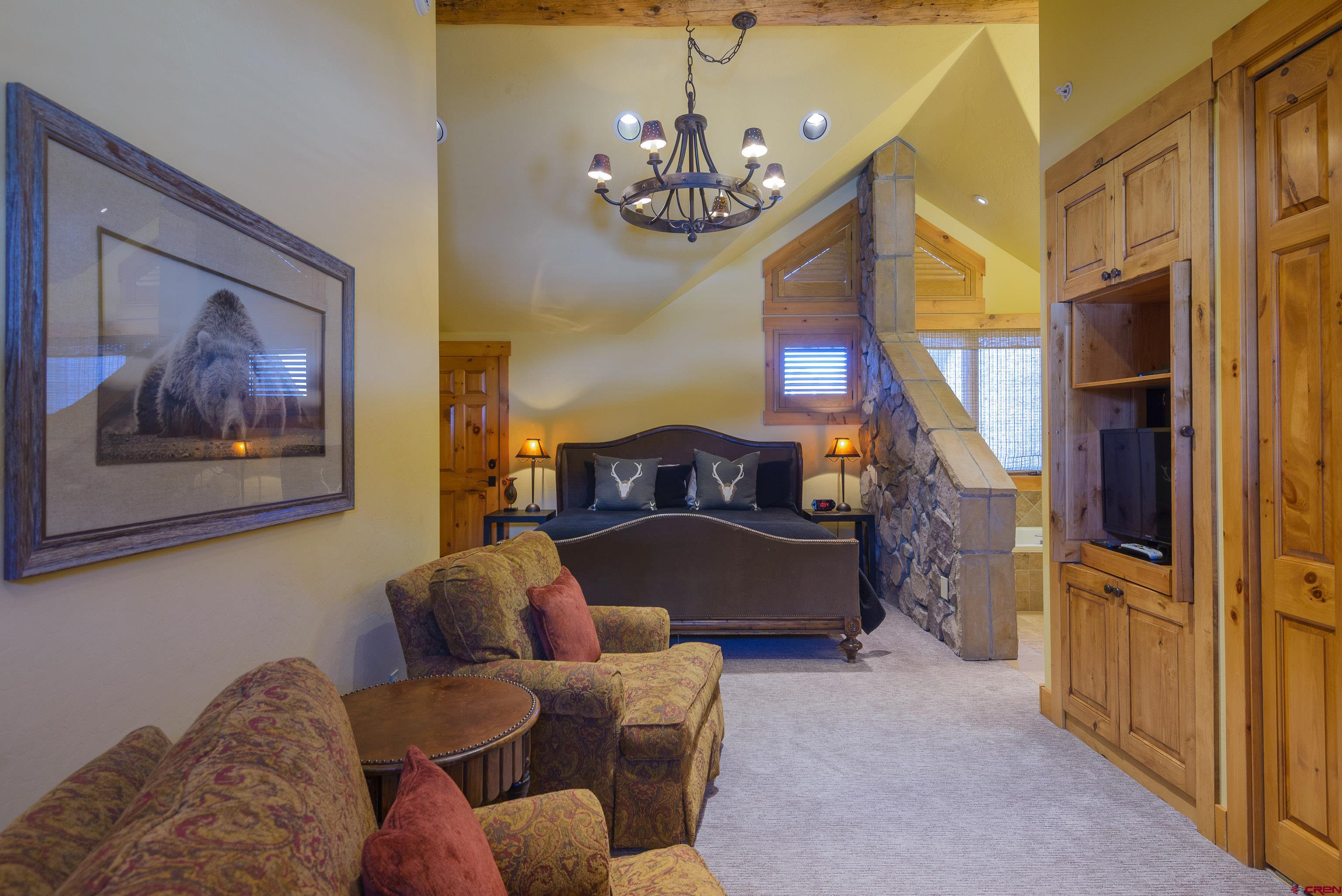 16 Snowmass Road, Unit 7 Crested Butte, CO 81225 - Photo 28 of 37 a living room with furniture a chandelier and a fireplace