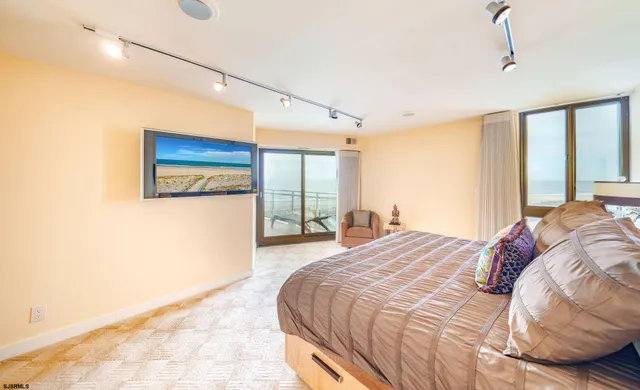 a bedroom with a bed a mirror and a large window