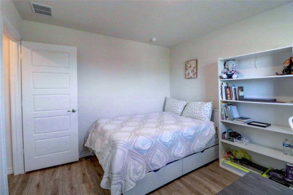 7404 Seton Place McKinney, TX 75071 - Photo 17 of 29 a bedroom with a bed and a book shelf