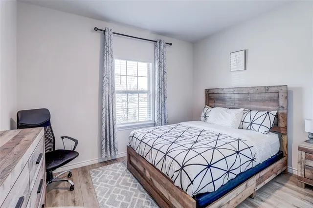 a bedroom with a bed a chair and a window