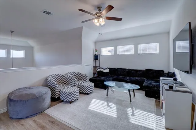 a living room with furniture a ceiling fan and a rug