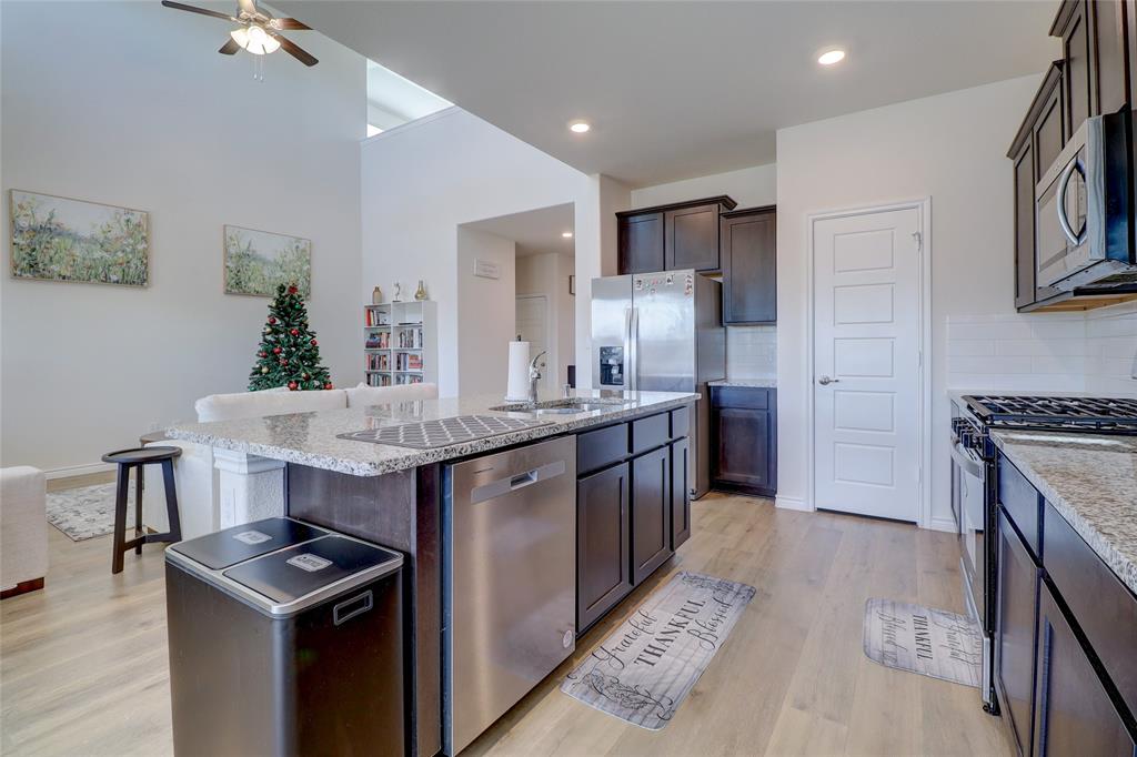 7404 Seton Place McKinney, TX 75071 - Photo 7 of 29 a kitchen with kitchen island a sink stove and refrigerator