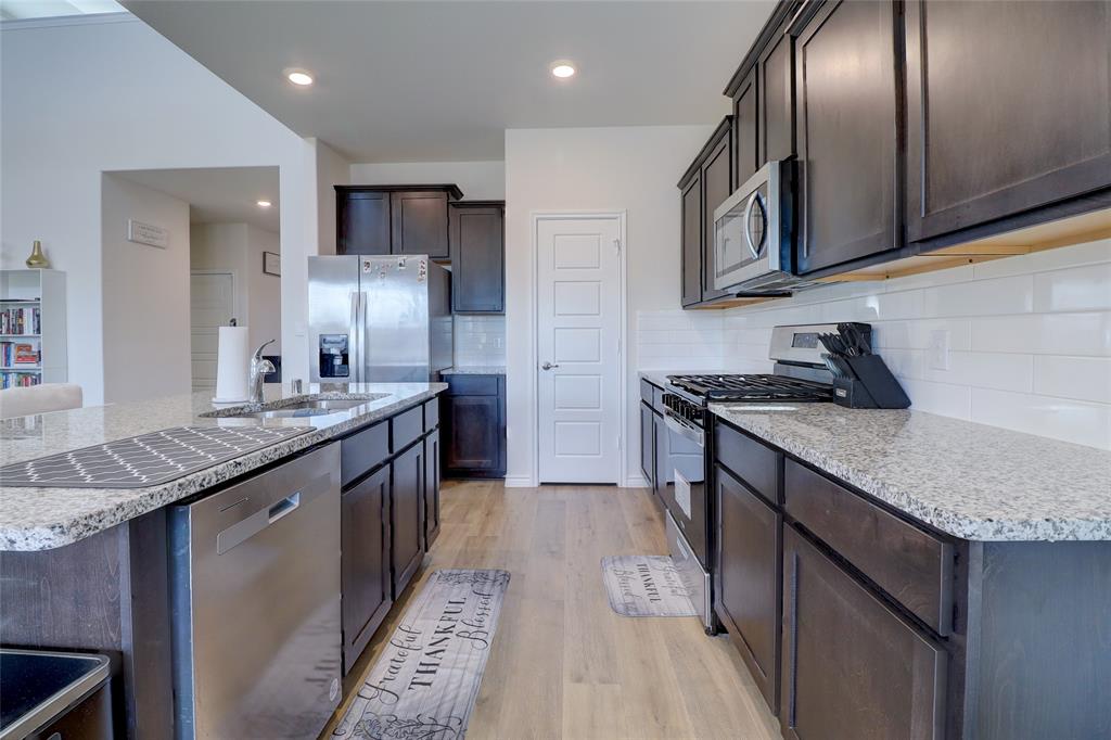 7404 Seton Place McKinney, TX 75071 - Photo 8 of 29 a kitchen with stainless steel appliances granite countertop a sink a stove and a refrigerator