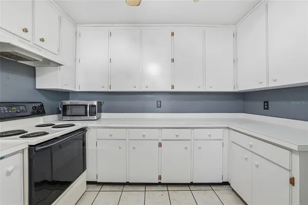 a kitchen with white cabinets and white appliances