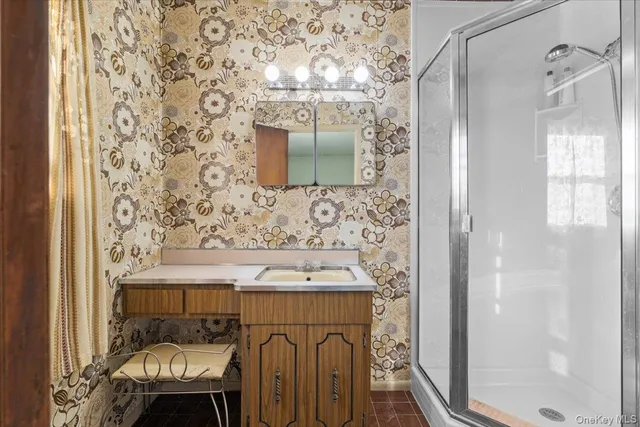 a bathroom with a sink a mirror and a shower