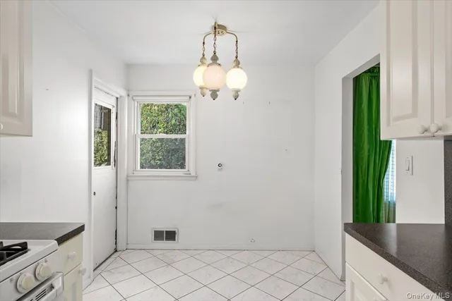 a view of kitchen with granite countertop cabinets and window
