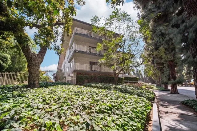 a view of a house with a big yard and potted plants
